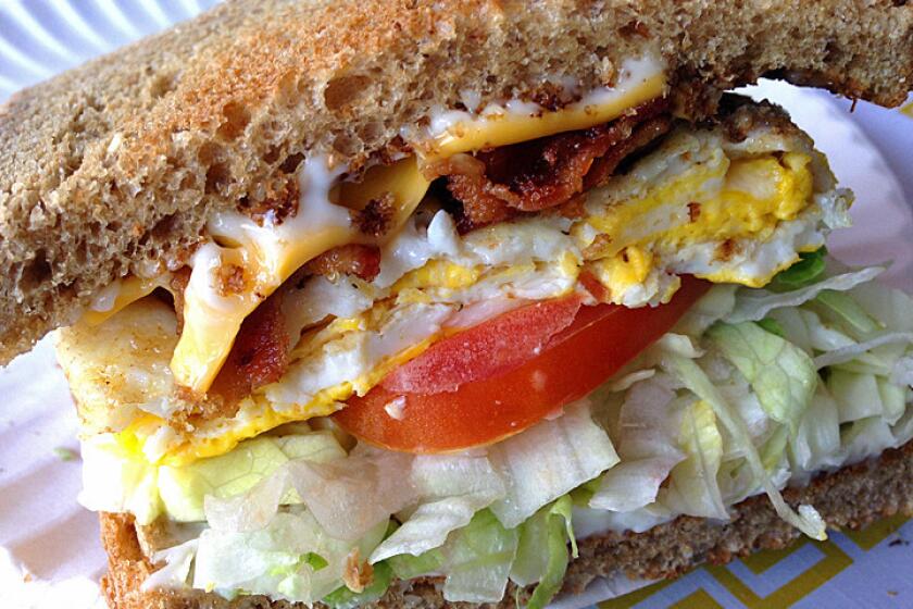 Old-school breakfast sandwich with cheese, bacon, egg, tomato and lettuce.