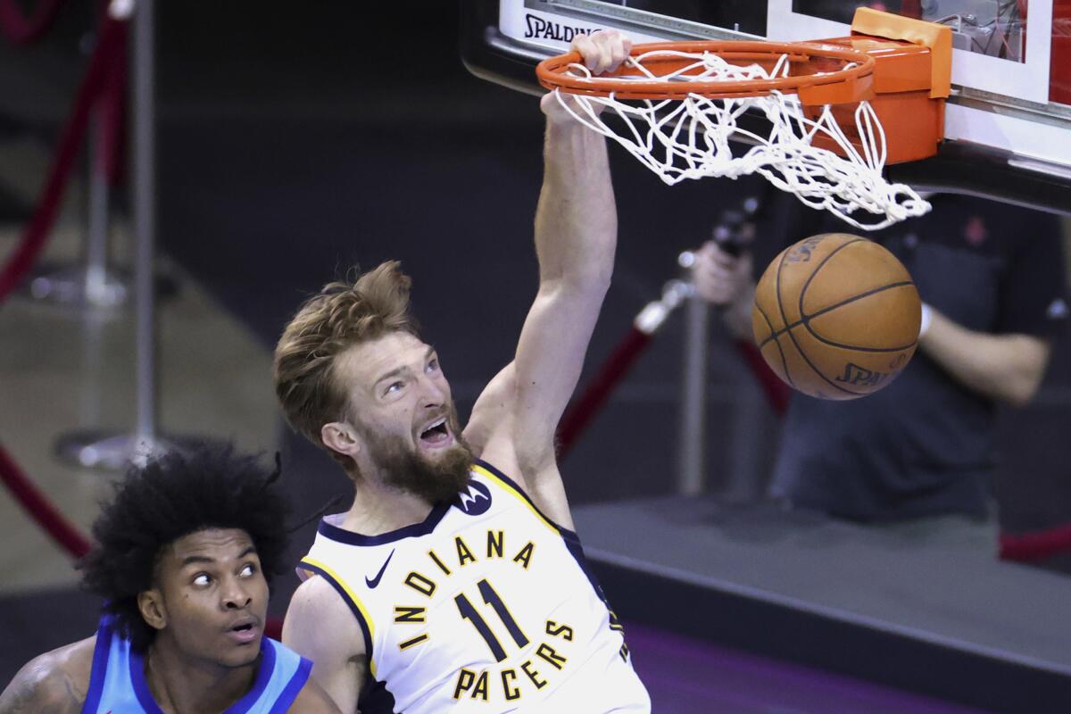 Indiana Pacers' Domantas Sabonis dunks against Houston Rockets' Kevin Porter Jr. during the fourth quarter of an NBA basketball game Wednesday, April 14, 2021, in Houston. (Carmen Mandato/Pool Photo via AP)