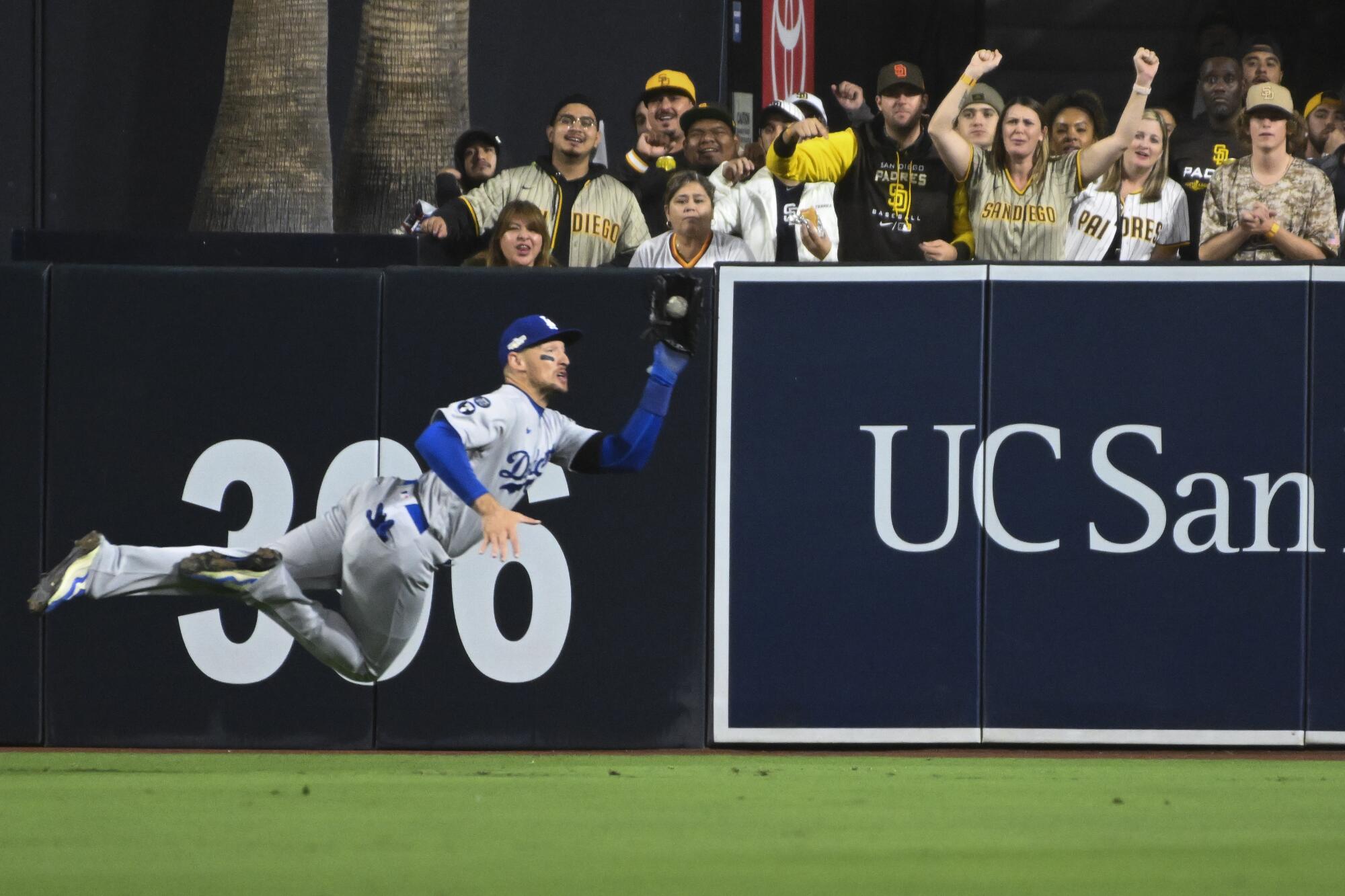 Dodgers center fielder Trayce Thompson dives to catch a ball.