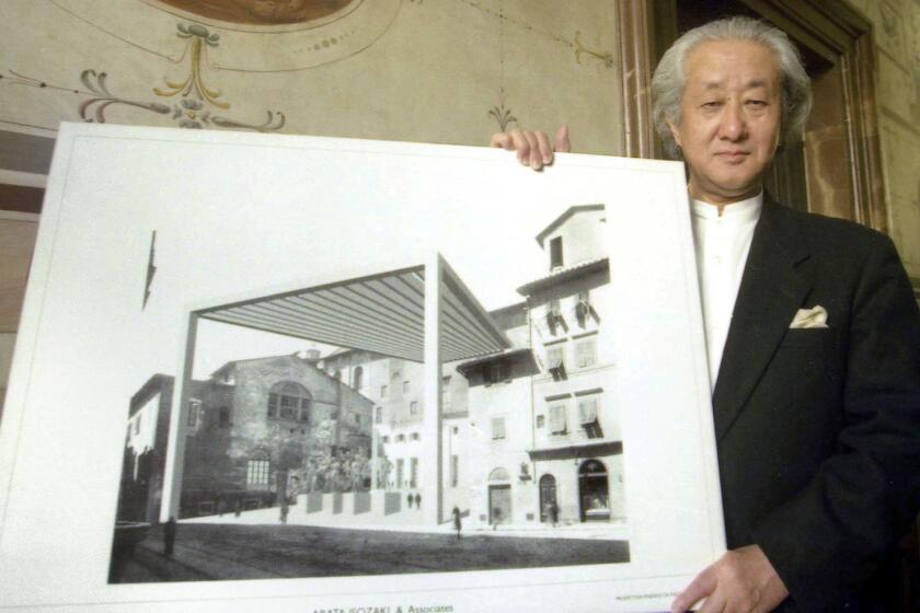 Arata Isozaki, wearing a formal black jacket, holds a rendering for a proposed addition to Florence's Uffizi Museum