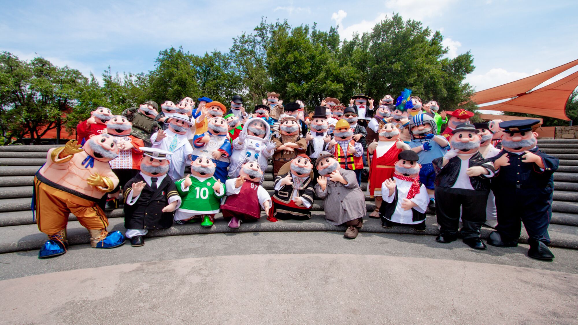 A group of people dressed as mustachioed characters in different costumes pose for a photo 