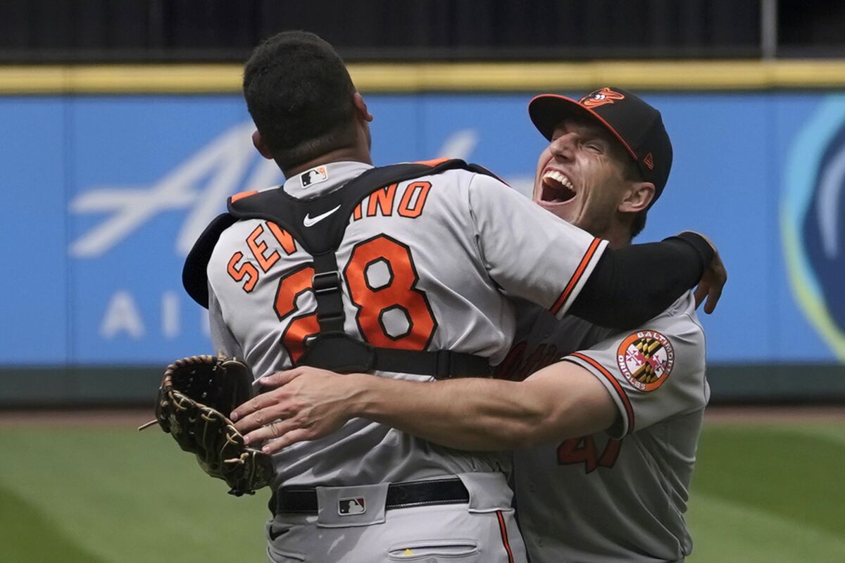 Baltimore Orioles starting pitcher John Means, right, hugs catcher Pedro Severino after Means threw a no-hitter in the team's baseball game against the Seattle Mariners, Wednesday, May 5, 2021, in Seattle. The Orioles won 6-0. (AP Photo/Ted S. Warren)