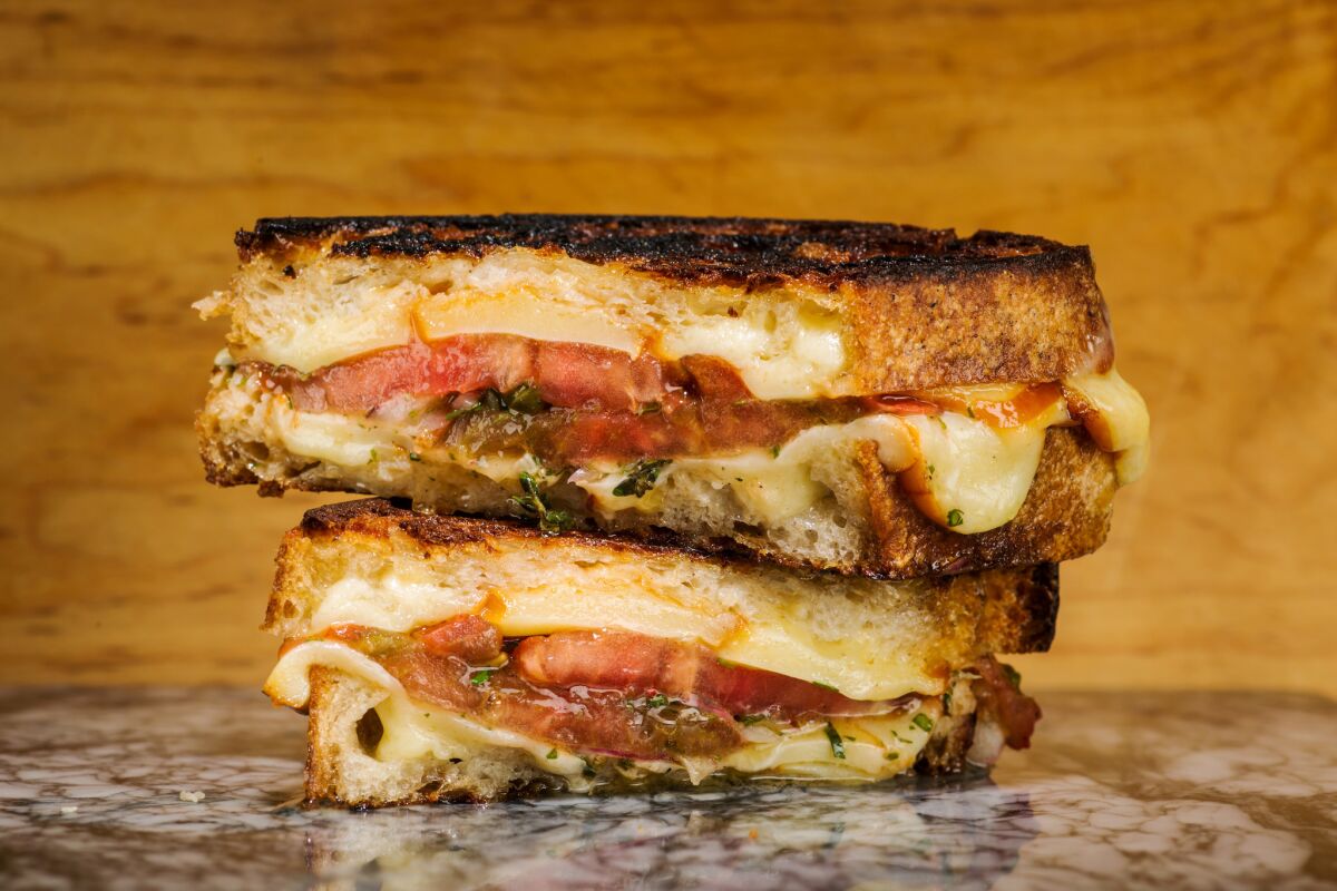 Grilled cheese sandwich made with smoked cheese and marinated tomatoes.