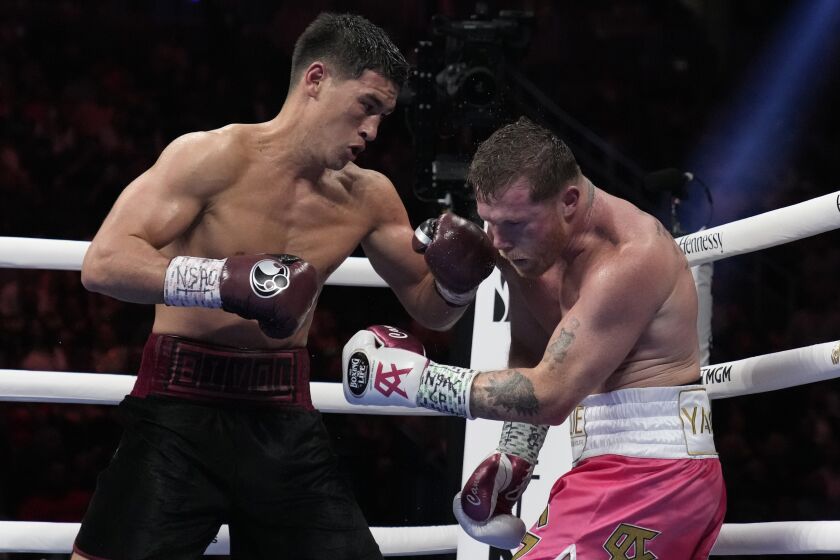 Dmitry Bivol, left, of Kyrgyzstan, throws a punch against Canelo Alvarez, of Mexico, during a light heavyweight title fight, Saturday, May 7, 2022, in Las Vegas. (AP Photo/John Locher)