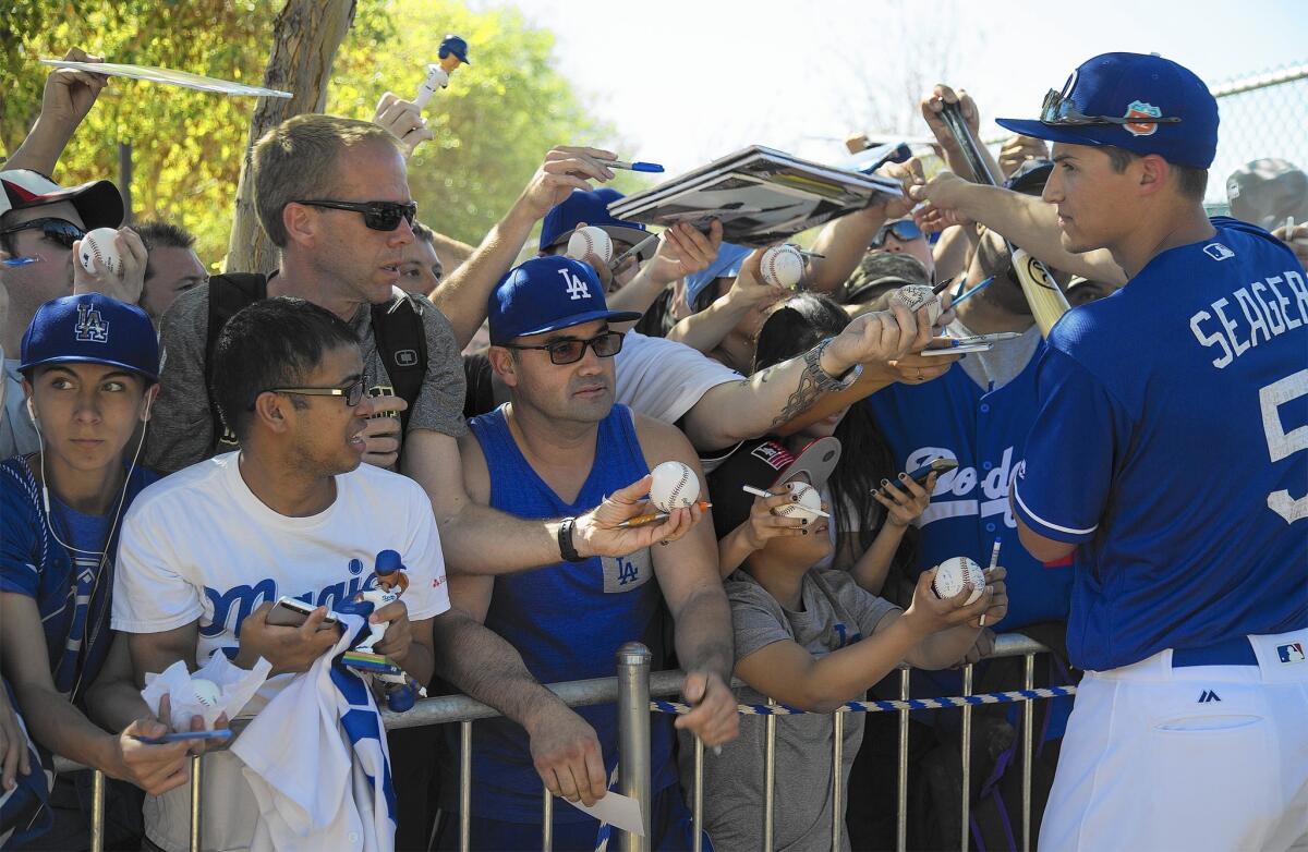 Fans crowd a barricade to get autographs from Dodger shortstop Corey Seager on Feb. 27. Local fans are in Year 3 of a TV blackout for the team, which signed an $8-billion rights deal with Time Warner Cable.