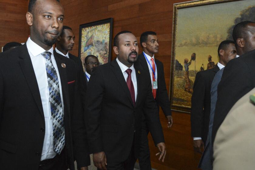 FILE - In this Sunday, Feb. 9, 2020, file photo, Ethiopia's Prime Minister Abiy Ahmed, center, arrives for the opening session of the 33rd African Union (AU) Summit at the AU headquarters in Addis Ababa, Ethiopia. Ahmed left Ethiopians breathless when he became the prime minister in 2018, introducing a wave of political reforms in the long-repressive country and announcing a shocking peace with enemy Eritrea. Now, Abiy is waging war in the defiant Tigray region. (AP Photo/File)
