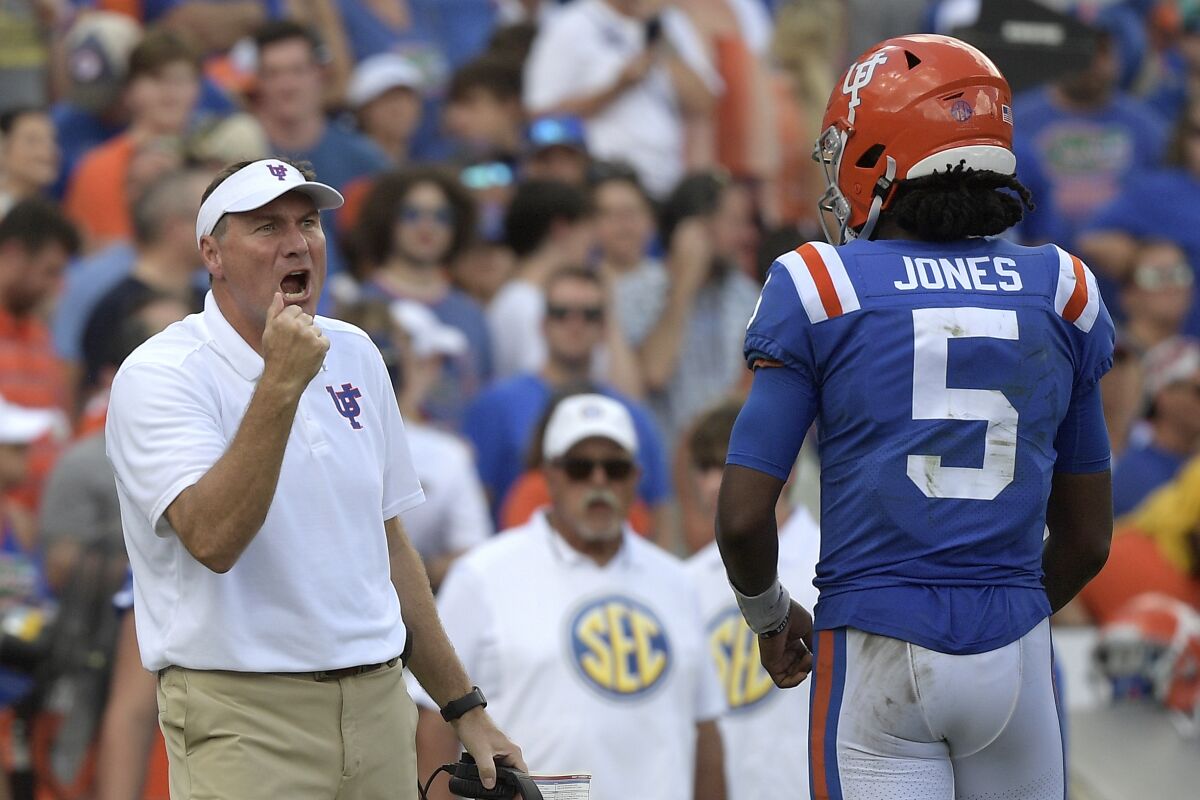 Florida head coach Dan Mullen, left, calls out instructions in front of quarterback Emory Jones (5) during the second half of an NCAA college football game against Vanderbilt, Saturday, Oct. 9, 2021, in Gainesville, Fla. (AP Photo/Phelan M. Ebenhack)