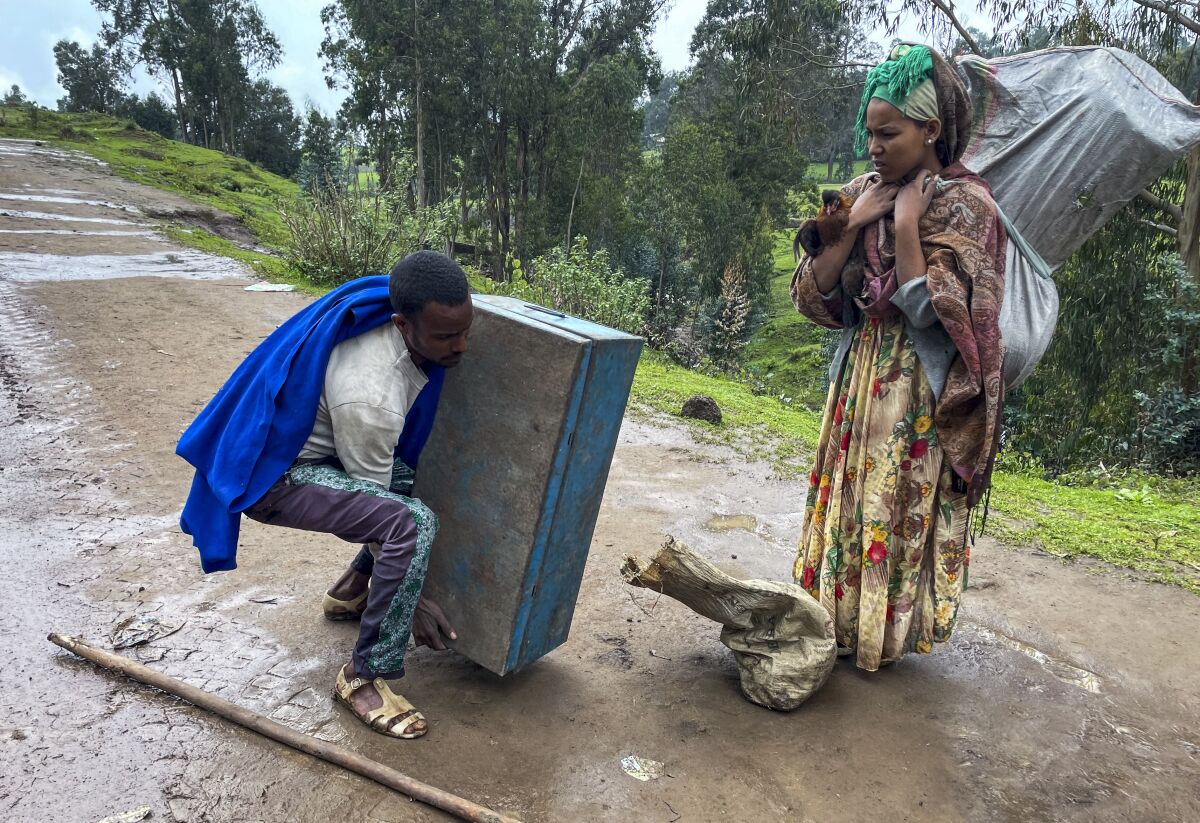 FILE - Senait Ambaw, right, who said her home had been destroyed by artillery, leaves by foot on a path near the village of Chenna Teklehaymanot, in the Amhara region of northern Ethiopia, on Sept. 9, 2021. The United Nations is predicting that a record 274 million people – who together would amount to the world’s fourth most-populous country – will require emergency humanitarian aid next year in countries including Afghanistan, Ethiopia, Myanmar, Syria and Yemen as they face a raft of challenges such as war, insecurity, hunger, climate change and the coronavirus pandemic. (AP Photo)