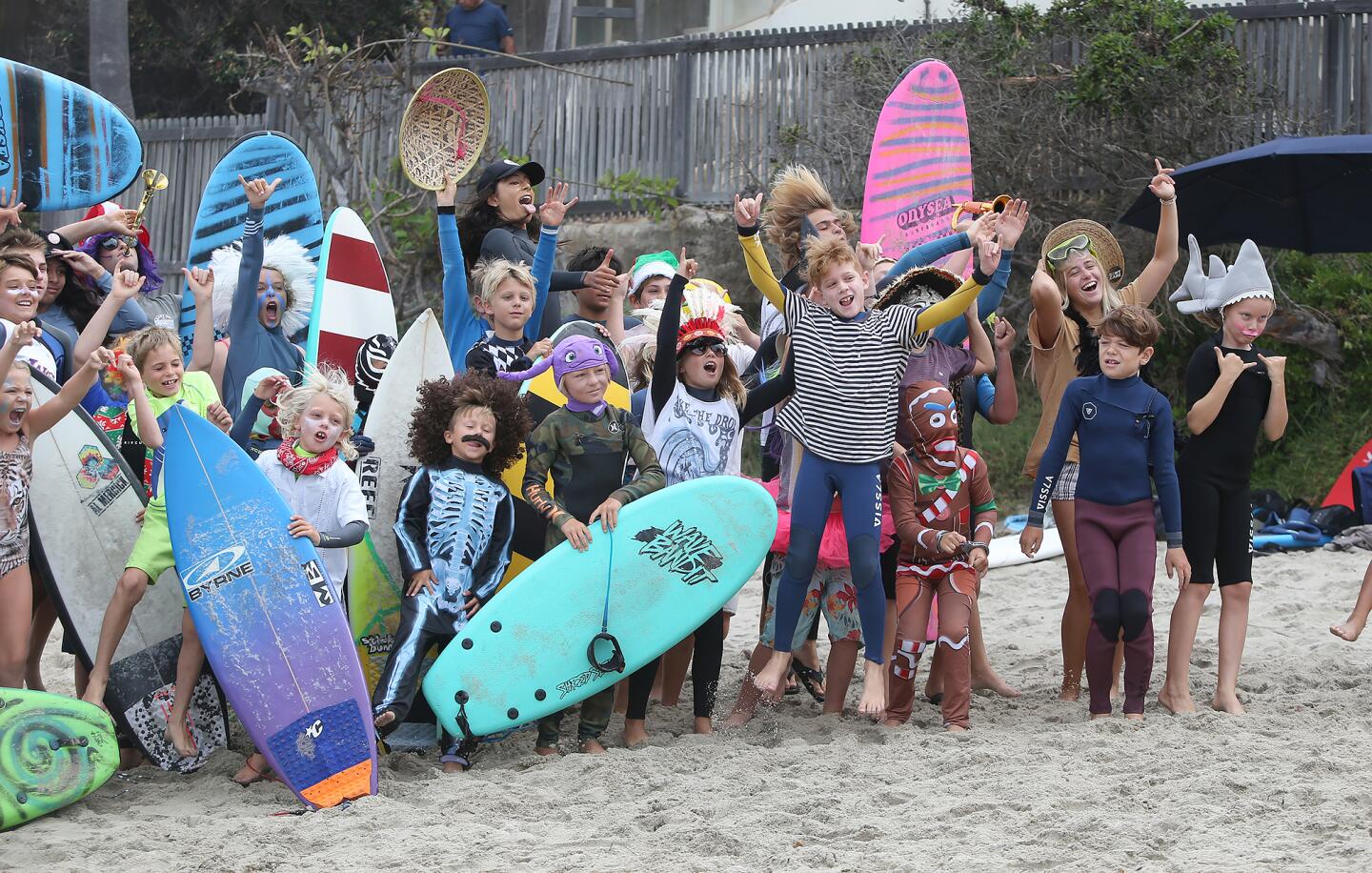Children dressed in costumes get ready to hit the waves Friday as part of the Laguna Beach Surf School summer program at Thalia Street Beach.