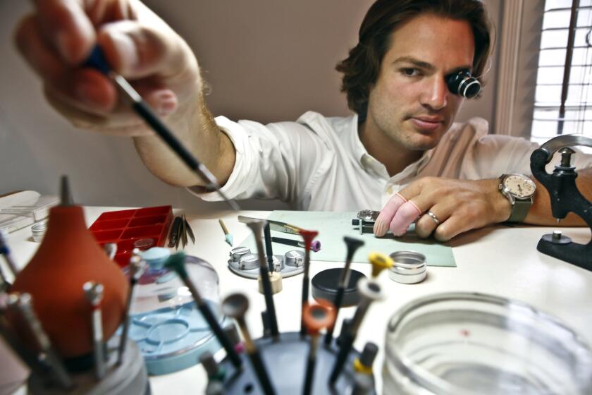 Cameron Weiss reaches for a screwdriver while assembling a watch at his workbench in his apartment in Beverly Hills.
