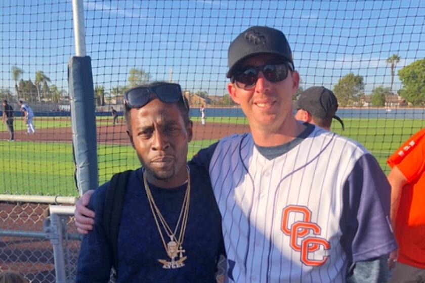 Former Orange Coast College baseball player LaBarian Willis and J.J. Altobelli pose for a photograph at Tuesday's game.