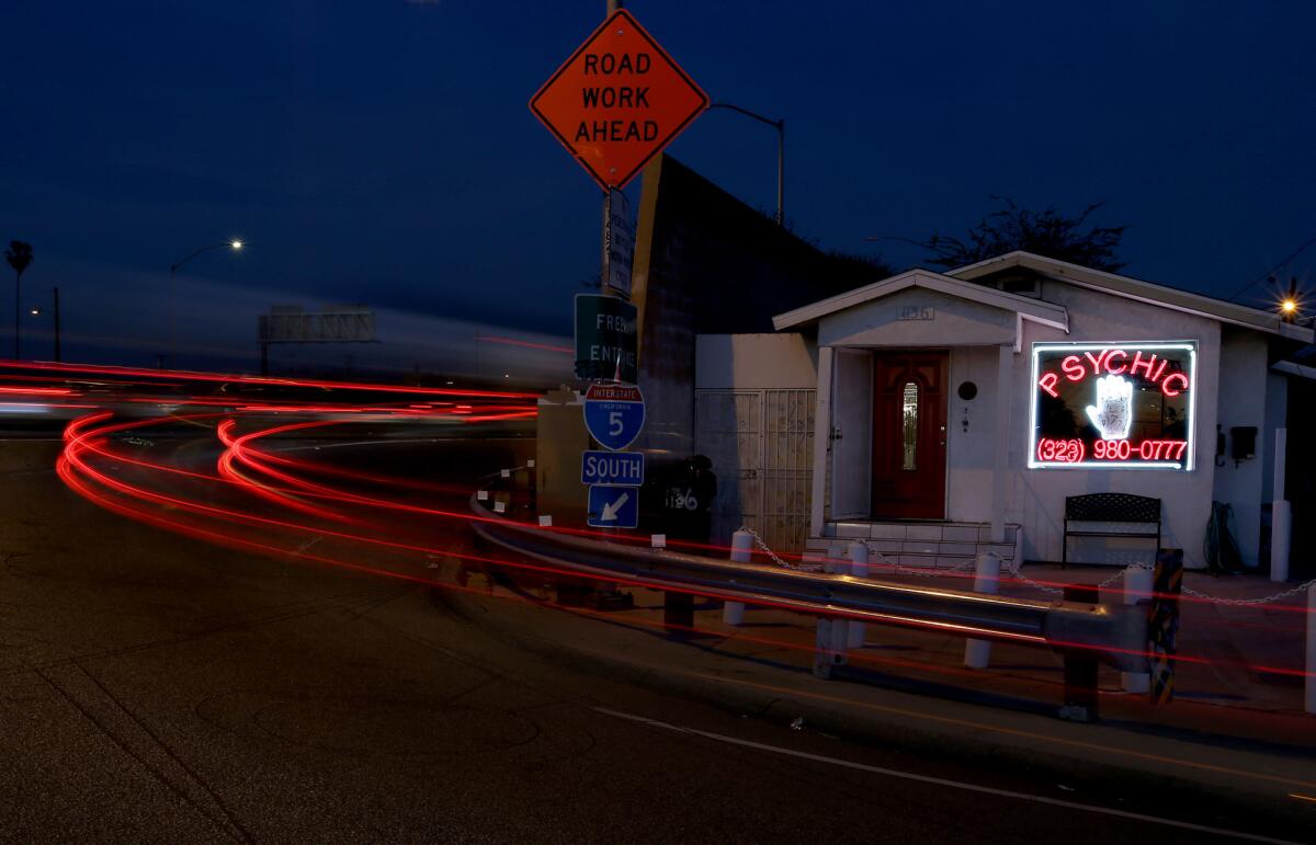 Taillights of motor vehicles streak past the home of a psychic on an on-ramp to the 5 Freeway in Los Angeles.