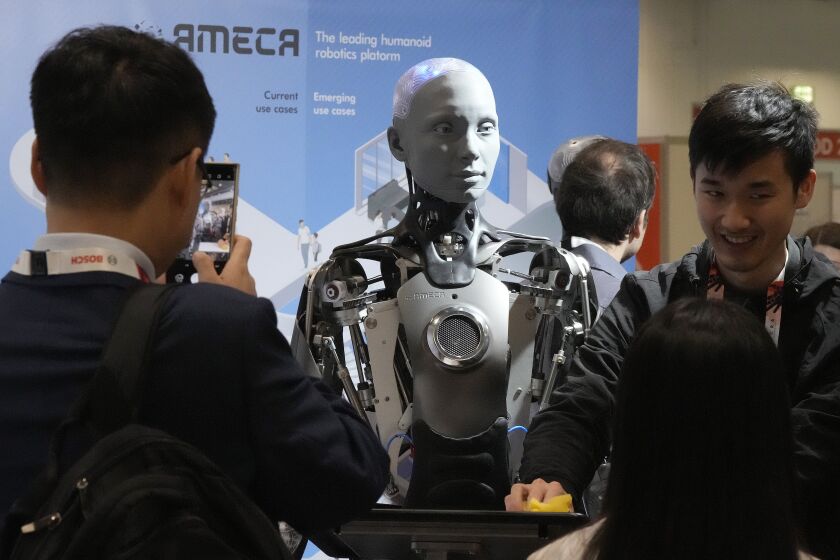 A robot designed by Engineers Arts and called AMECA, interacts with visitors during the International Conference on Robotics and Automation ICRA in London, Tuesday, May 30, 2023.The 2023 ICRA brings together the world's top academics, researchers, and industry representatives to show the newest developments. Ameca is a humanoid robot platform for human-robot interaction. (AP Photo/Frank Augstein)