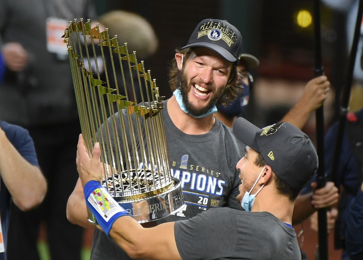 Dodgers Clayton Kershaw, left, and Austin Barnes hold the championship trophy.