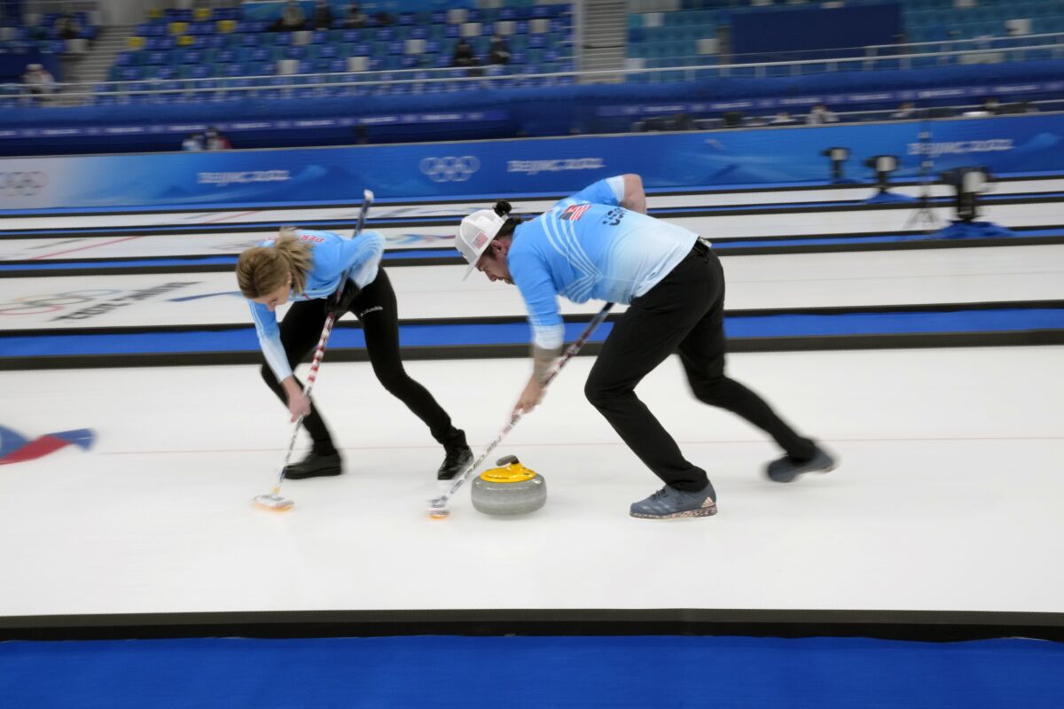 United States' Christopher Plys, and Victoria Persinger, sweep the ice, during the mixed doubles curling match against Sweden, at the 2022 Winter Olympics, Friday, Feb. 4, 2022, in Beijing. (AP Photo/Nariman El-Mofty)
