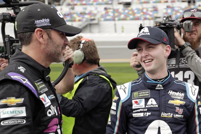William Byron, right, is congratulated by Jimmie Johnson, left, after winning the pole position during qualifying for the Daytona 500 auto race at Daytona International Speedway, Sunday, Feb. 10, 2019, in Daytona Beach, Fla. (AP Photo/John Raoux)