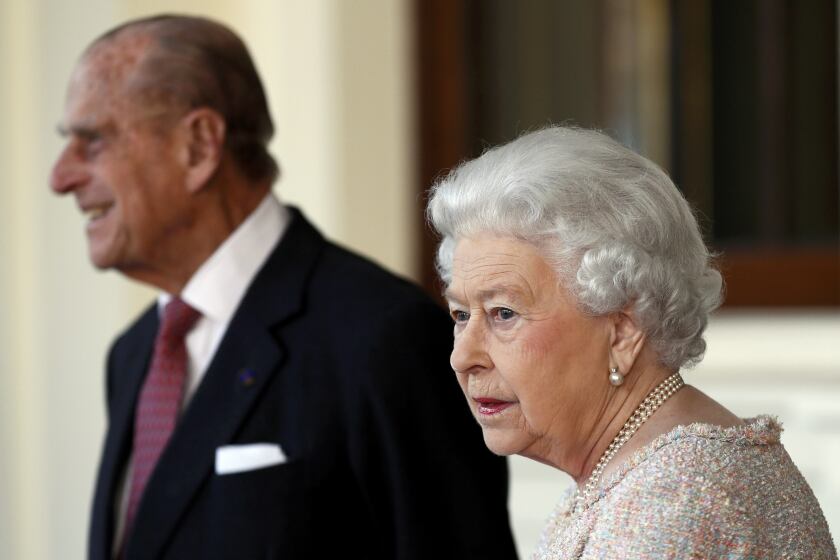FILE - In this Thursday, Nov. 3, 2016 file photo, Britain's Prince Philip and Queen Elizabeth II bid farewell to Colombia's President Juan Manuel Santos, and his wife Maria Clemencia de Santos, following their state visit, at Buckingham Palace in London. Queen Elizabeth II and her husband have received their COVID-19 vaccinations. Buckingham Palace officials said in a statement that the 94-year-old monarch and 99-year-old Prince Philip received their jabs on Saturday, Jan. 9, 2021, joining some 1.5 million people in Britain who have been given the first dose of a vaccine against the coronavirus. (Stefan Wermuth/Pool Photo via AP, File)