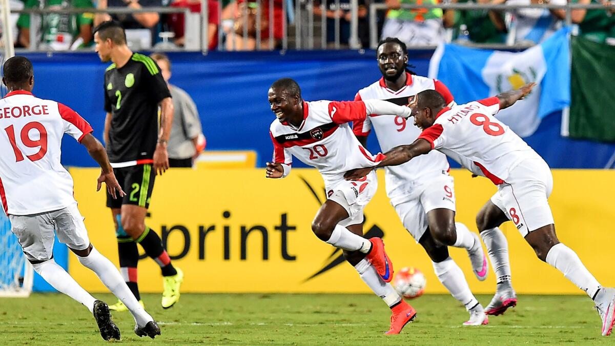 Trinidad and Tobago's Keron Cummings (20) celebrates one of his two goals against Mexico with teammates during a Gold Cup group game on Wednesday night in Charlotte, N.C.