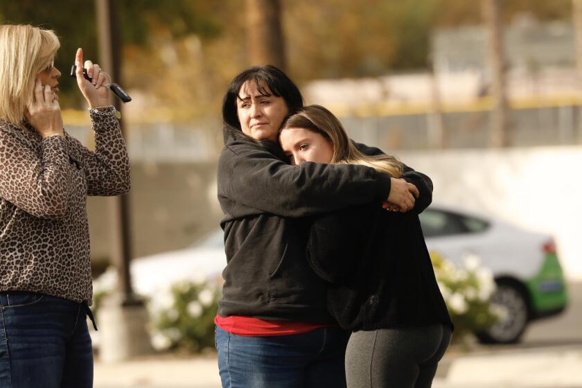 SANTA CLARITA CA NOVEMBER 14, 2019 -- A parent is reunited with their child outside Saugus High School, where at least five people were injured— two critically — when a gunman opened fire on the Santa Clarita campus early Thursday, November 14, 2019. (Al Seib / Los Angeles Times)