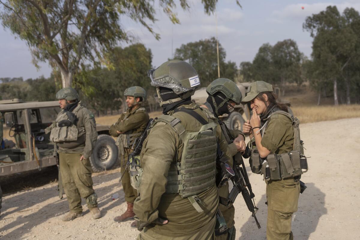 Israeli soldiers gather near the Israeli-Gaza border in southern Israel before they enter the Gaza Strip.