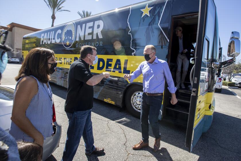 Santa Clarita, CA - August 28,2021: Kevin Faulconer , right, greets state senator Scott Wilk, center, as he steps off his campaign bus at the Black Bear Diner on Saturday, Aug. 28, 2021 in Santa Clarita, CA. (Brian van der Brug / Los Angeles Times)