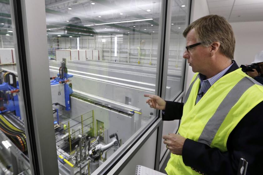 FILE - In this May 19, 2016, file photo, Eric Lindblad, vice president in charge of the Boeing 777X wing, looks over the "clean" room area of the new 777X Composite Wing Center, a day ahead of its grand opening in Everett, Wash. Lindblad, the executive who manages the Boeing 737 Max program and the Seattle-area factory where the now-grounded plane is built, said he planned to retire last summer, and a Boeing spokesman said Thursday, July 11, 2019, that Lindblad's decision was unrelated to two deadly accidents involving Max jets. (AP Photo/Elaine Thompson, File)