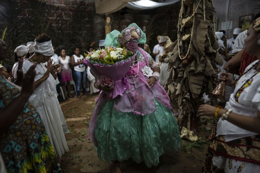 Members of the Afro Brazilian faith, Candomble, dance during a ritual honoring Obaluae, the deity of earth and health, at their temple on the outskirts of Salvador, Brazil, Sunday, Sept. 18, 2022. Today just a small minority practices Afro Brazilian religions, and there have been increased reports of incidents of religious intolerance targeting them, particularly at the hands of members of Pentecostal and neo-Pentecostal churches. (AP Photo/Rodrigo Abd)