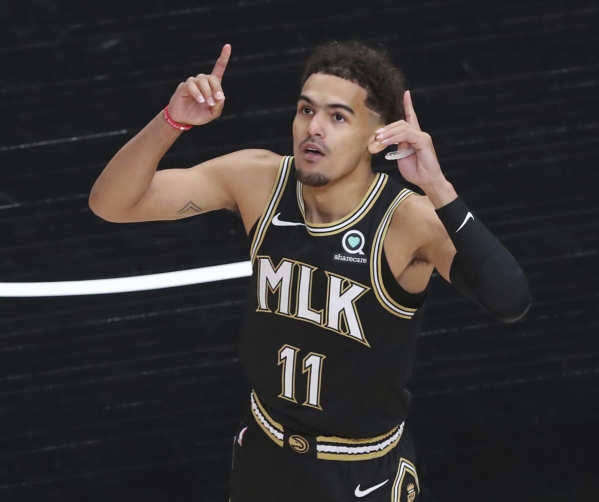 Trae Young points toward the sky.
