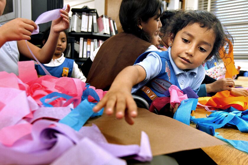 Edith Moreno, right, works on an arts and crafts project during a Girl Scout meeting at Grape Street Elementary School in Watts.