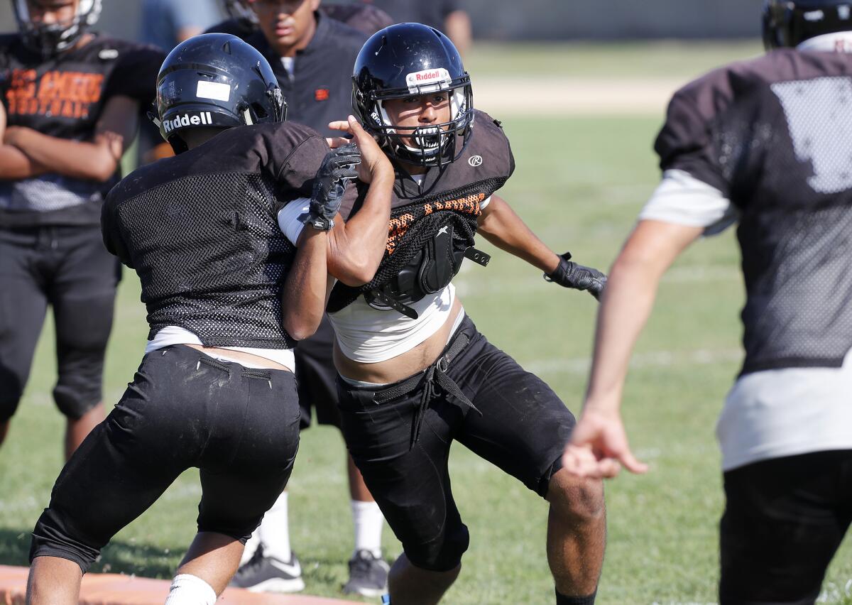 Juan Contreras, center, sheds a block during practice at Los Amigos on Friday.