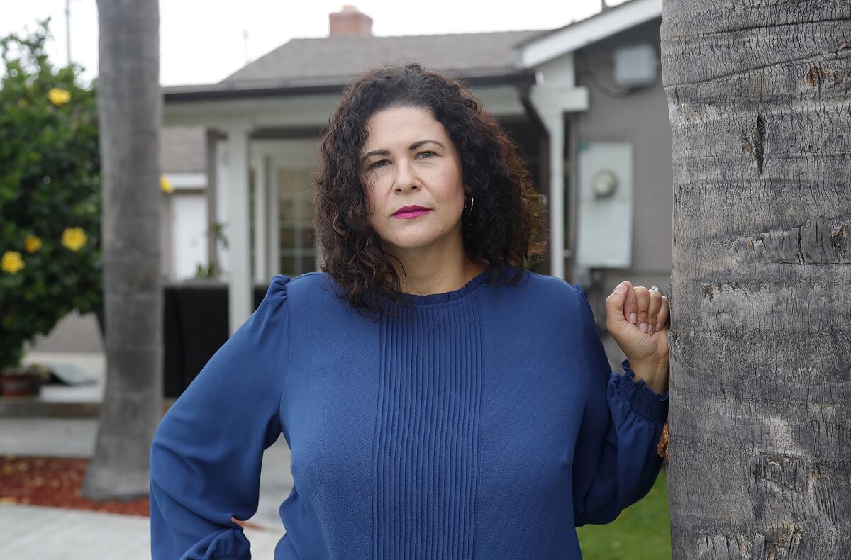 Ada Briceño stands next to a palm tree