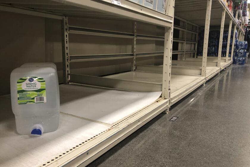 Un contenedor de agua en una estantería vacía en un supermercado en Anchorage, Alaska, el domingo 1 de marzo de 2020. (AP Foto/Mark Thiessen)