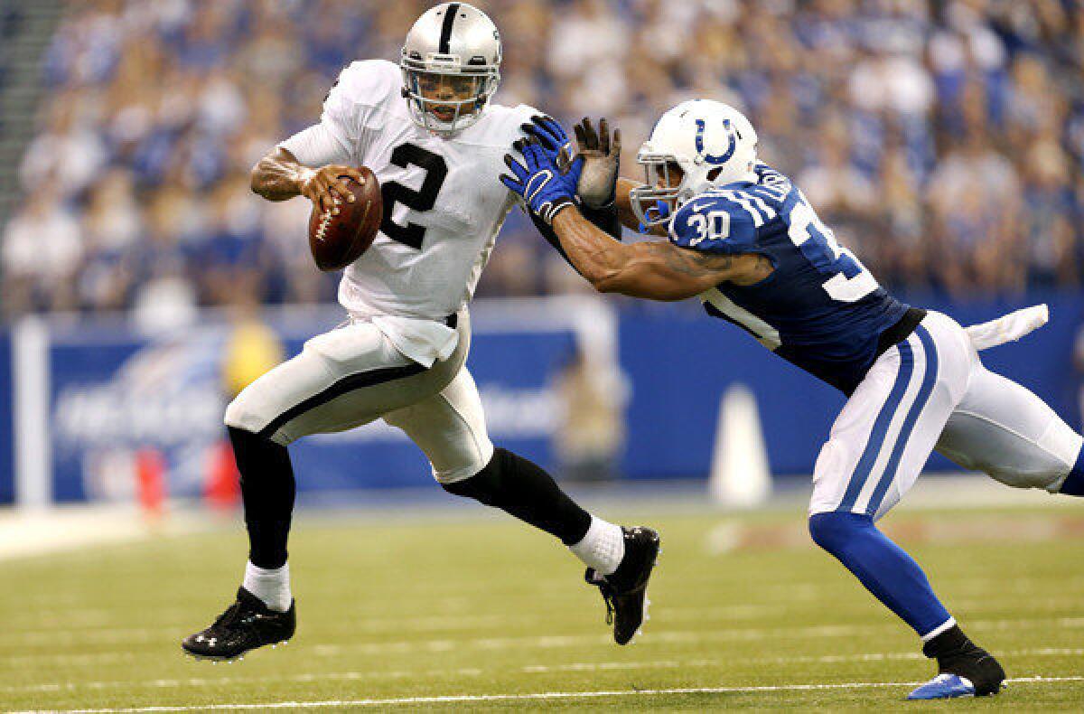 Raiders quarterback Terrelle Pryor tries to get past Colts safety LaRon Landry in second half Sunday in Indianapolis.
