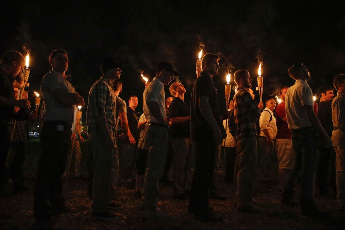 In this 2017 file photo, multiple White nationalist groups march with torches through the University of Virginia.