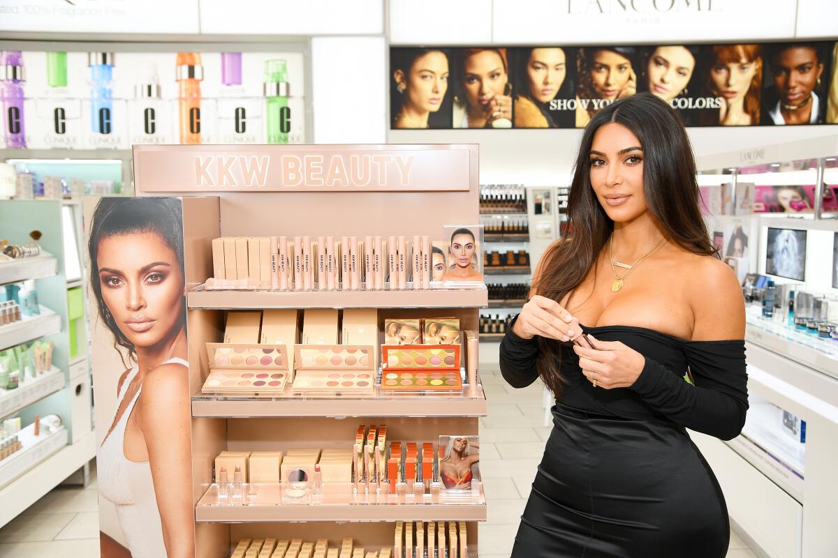 Kim Kardashian in a black dress at a beauty store.