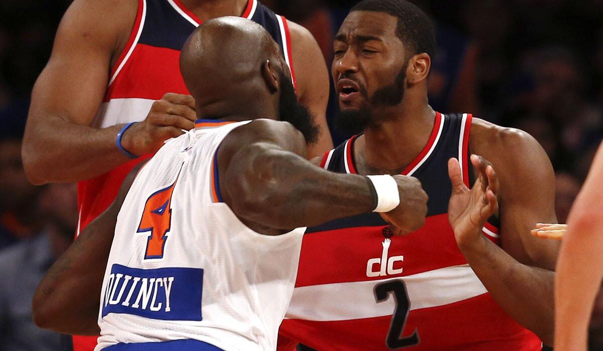 Knicks forward Quincy Acy takes a swing at Wizards point guard John Wall (2) in the fourth quarter of their Christmas Day game at Madison Square Garden.