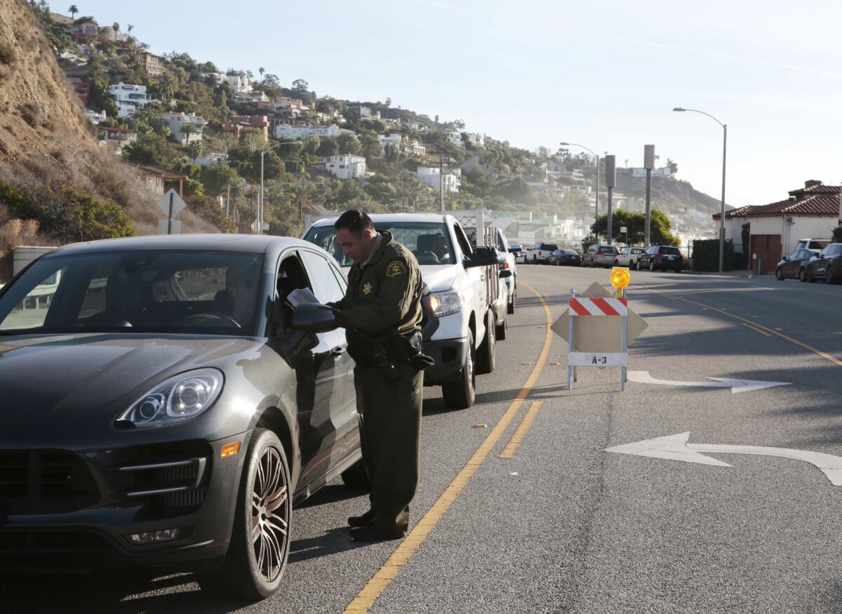 Law enforcement checks the IDs of residents returning home to Malibu.