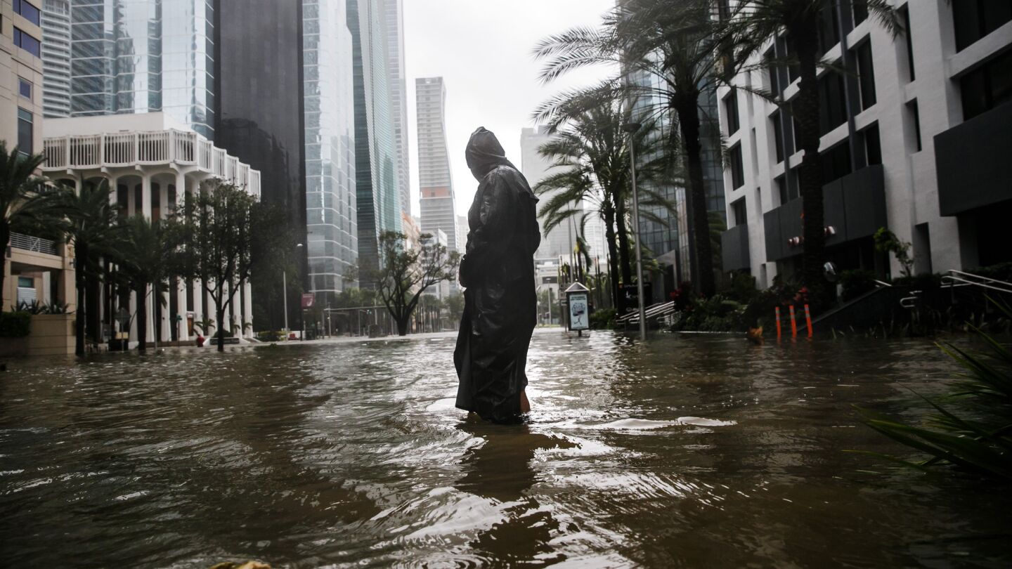 Peter Moodley wades through floodwater in downtown Miami.