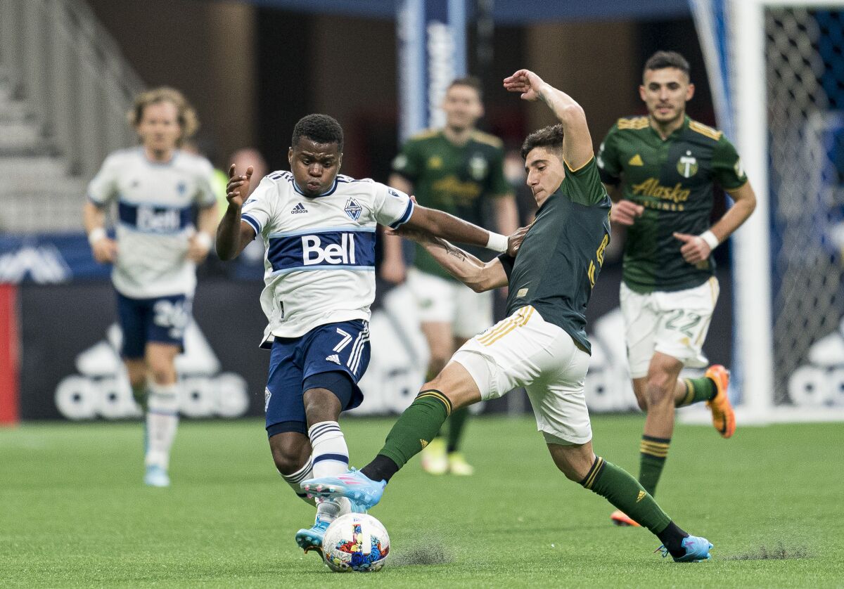 Portland Timbers defender Claudio Bravo (5) tries to breaks up the run of Vancouver Whitecaps forward Déiber Caicedo (7) during the first half of an MLS soccer match Saturday, April 9, 2022, in Vancouver, British Columbia. (Rich Lam/The Canadian Press via AP)