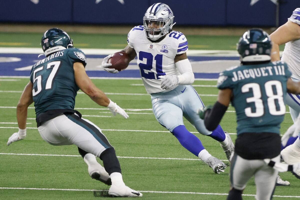 Dallas Cowboys running back Ezekiel Elliott (21) runs the ball as Philadelphia Eagles linebacker T.J. Edwards (57) and cornerback Michael Jacquet (38) close in to make the stop in the second half of an NFL football game in Arlington, Texas, Sunday, Dec. 27. 2020. (AP Photo/Michael Ainsworth)
