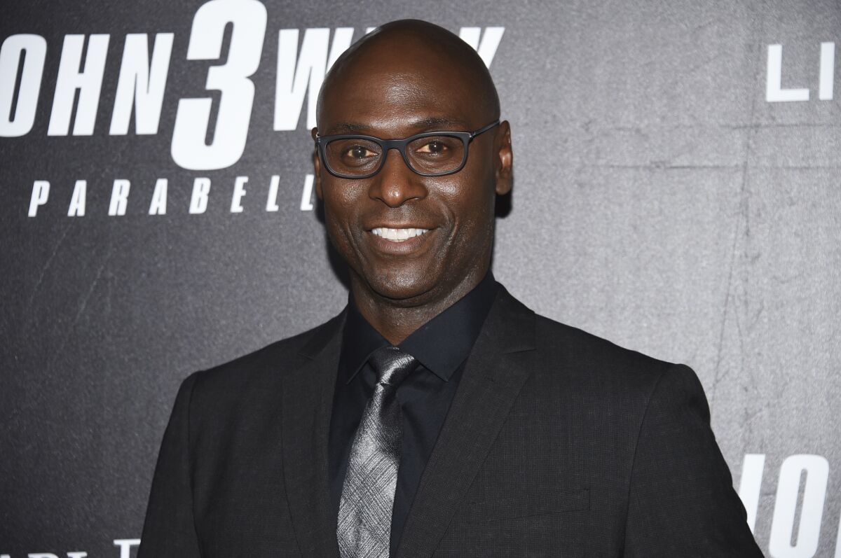 Actor Lance Reddick smiles at a movie premiere