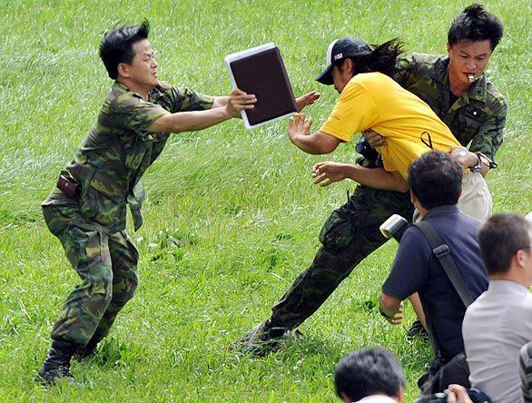At Chishan evacuation center in Kaohsiung County, Taiwan, a man is stopped by troops as he tries to take a helicopter back to his hometown that was hit by a mudslide.
