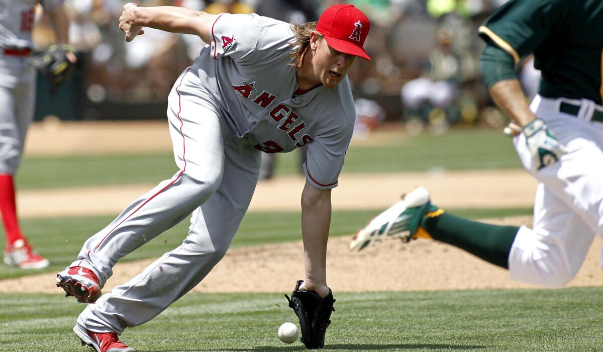 Los Angeles Angels pitcher Jared Weaver fields a bunt as Oakland Athletics' Billy Burns runs to first during an Angels' 4-1 loss to the A's on Saturday.