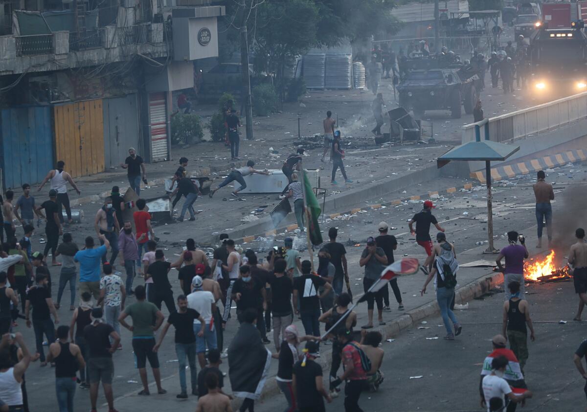 Antigovernment protesters set fires and block roads while security forces fire tear gas during a protest Oct. 2 in Baghdad.