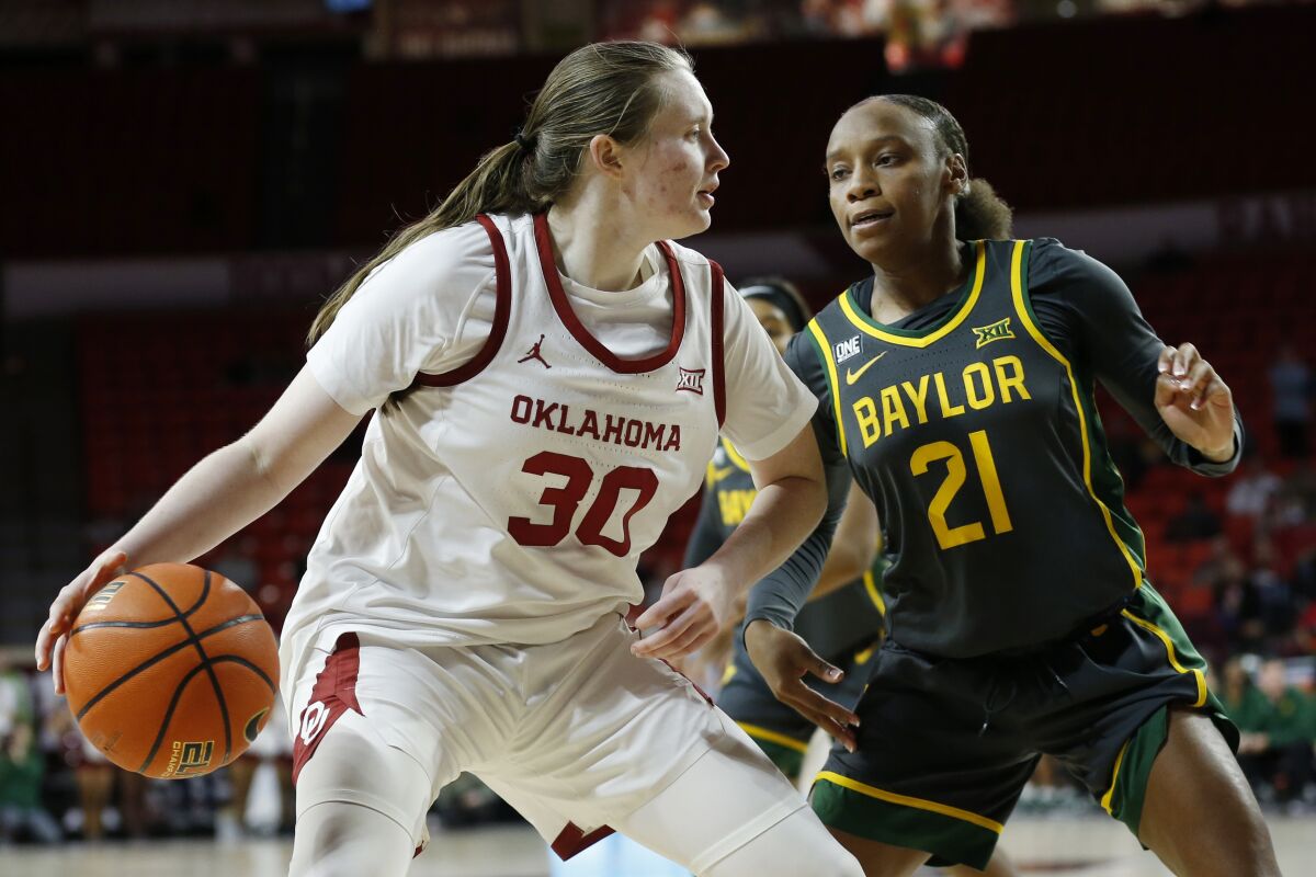 Oklahoma guard Taylor Robertson (30) drives the ball against Baylor guard Ja'Mee Asberry (21) during the second half of an NCAA college basketball game Wednesday, Jan. 12, 2022, in Norman, Okla. (AP Photo/Garett Fisbeck)