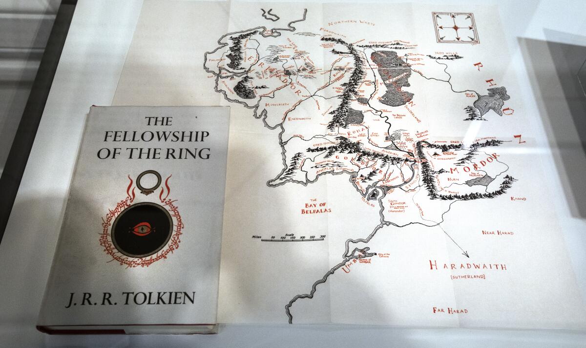 A framed map with a book titled "The Fellowship of The Ring" on top of it