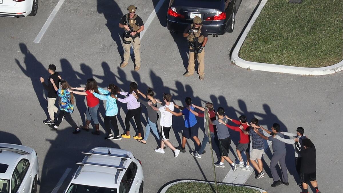 Students are led out of Marjory Stoneman Douglas High School in Parkland, Fla., after the Feb. 14 shooting.