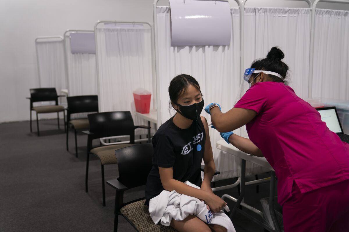 Melody Chuang, 14, receives her first dose of the Pfizer-BioNTech COVID-19 vaccine at a site in Santa Ana.