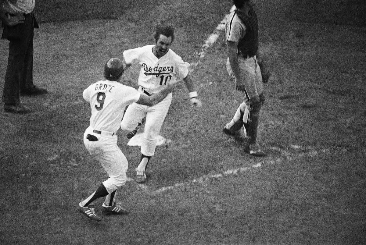 Ron Cey crosses home plate and leaps into the arms of teammate Jerry Grote after scoring on a single by Bill Russell.