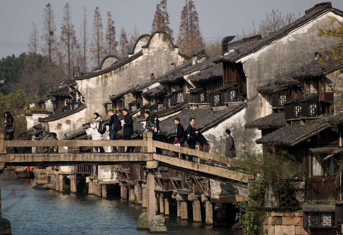 Participants cross a bridge to enter the World Internet Conference venue in the scenic town of Wuzhen in eastern China's Zhejiang province on Dec. 16, 2015.